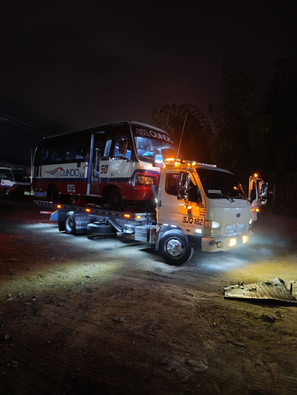 Operativo nocturno con una buseta de Nuevo Rápido Quindío sobre la grúa