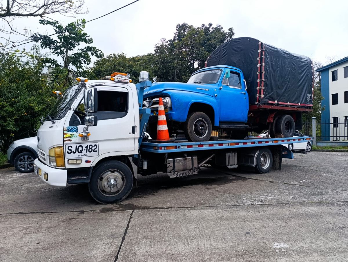 Camión de estacas clásico azul transportado sobre plataforma