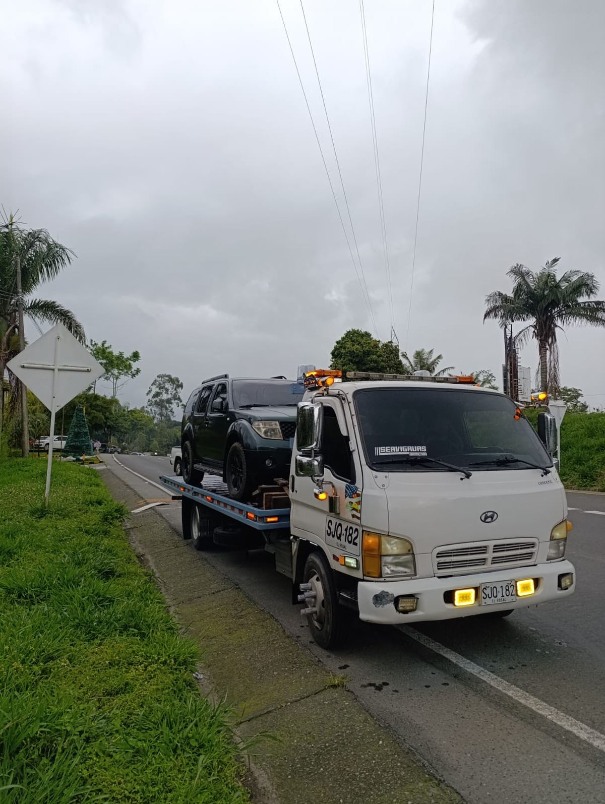 Camioneta Nissan Pathfinder sobre la grúa de plataforma en una vía del Quindío
