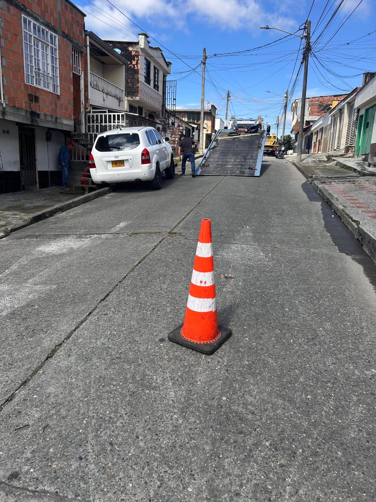 Plataforma de grúa desplegada en una calle de Armenia para cargar una camioneta