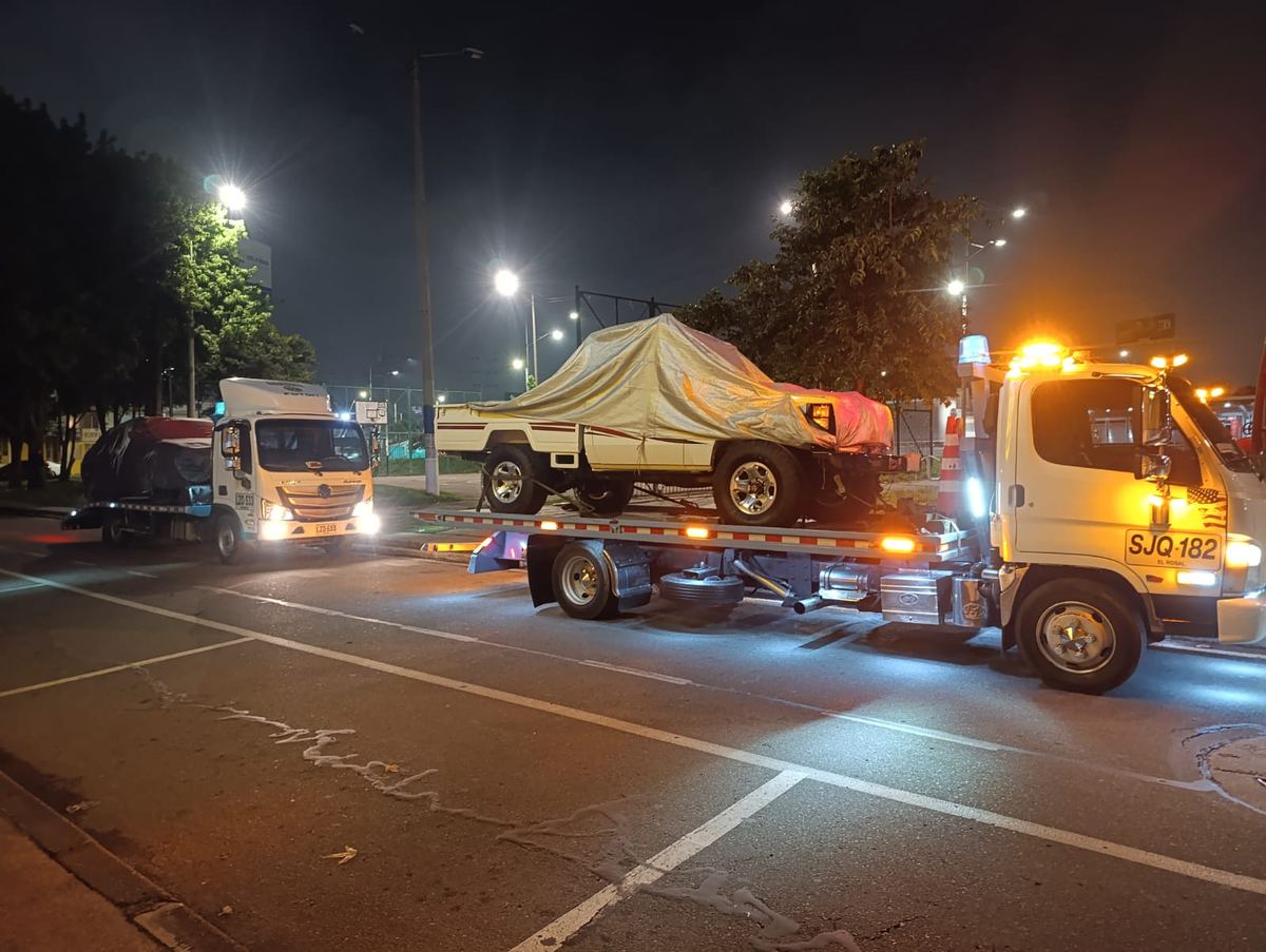 Servicio nocturno de grúa con un campero cubierto con lona sobre la plataforma
